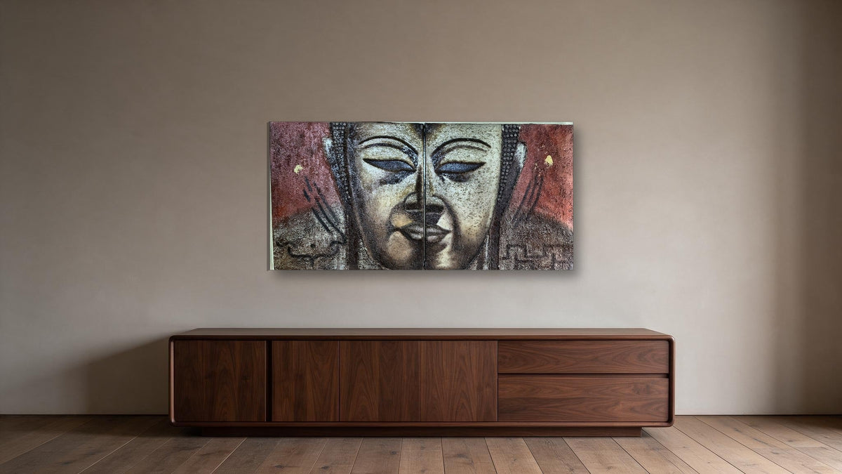 Hand-painted Buddha face diptych in textured relief across two panels, shown on a wide feature wall