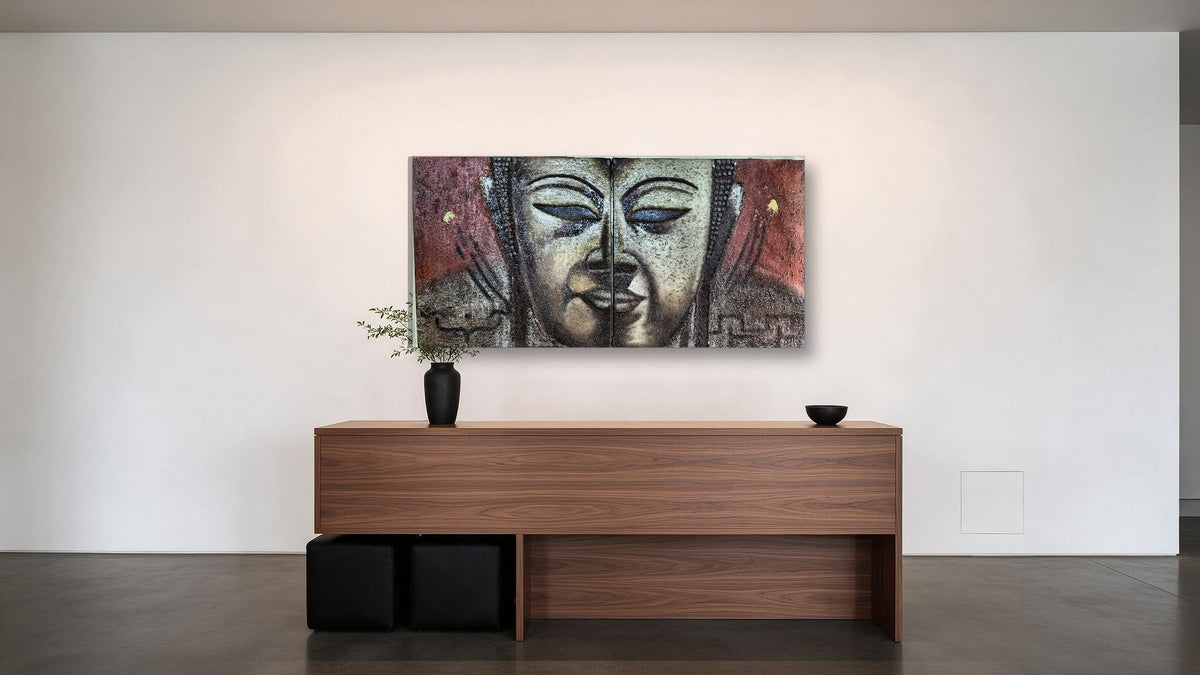 Hand-painted Buddha face diptych in textured relief across two panels, shown in an office reception